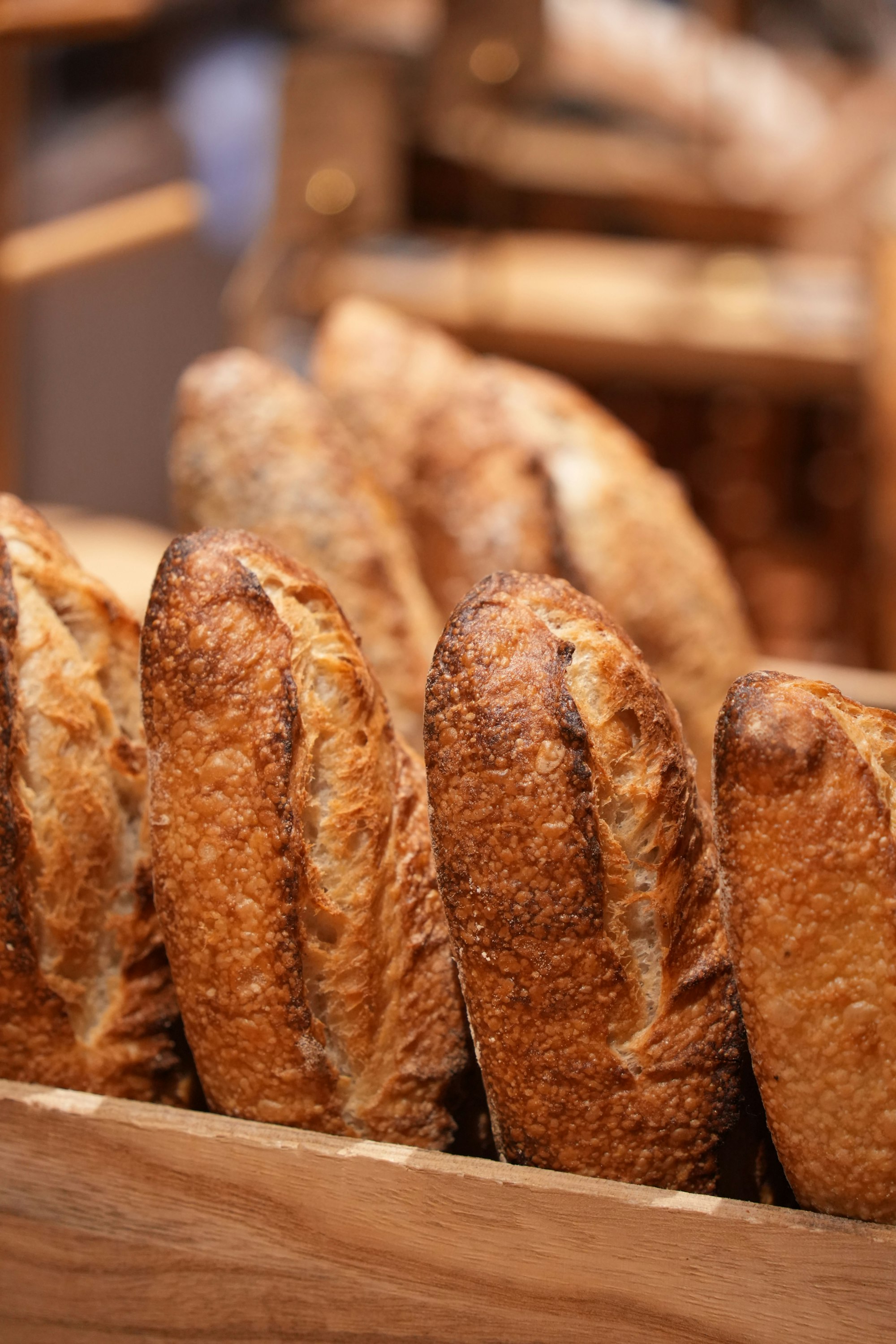 Crusty loaves lined up in a wooden crate
