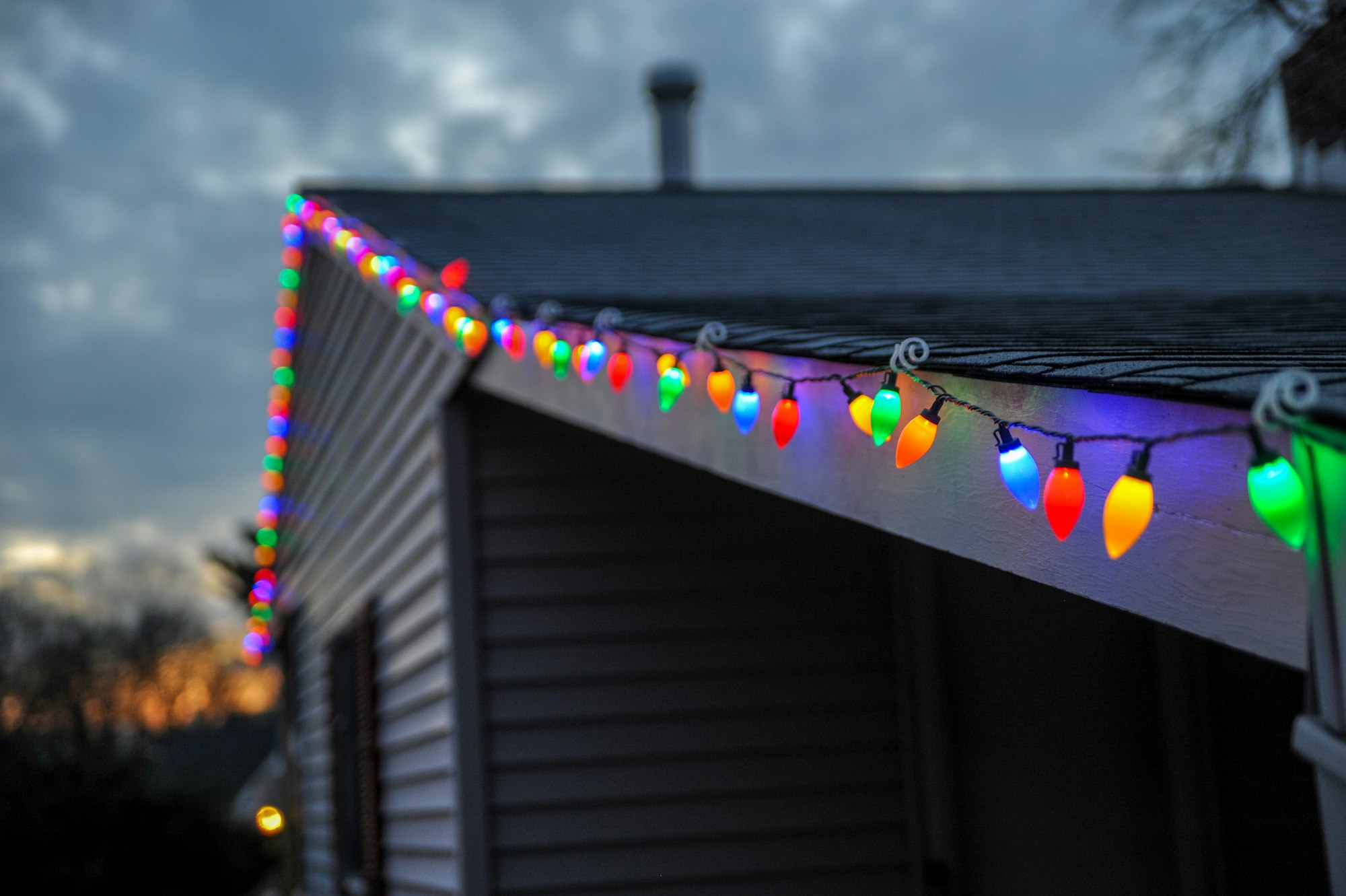 Colored Christmas bulbs clipped along a roof edge