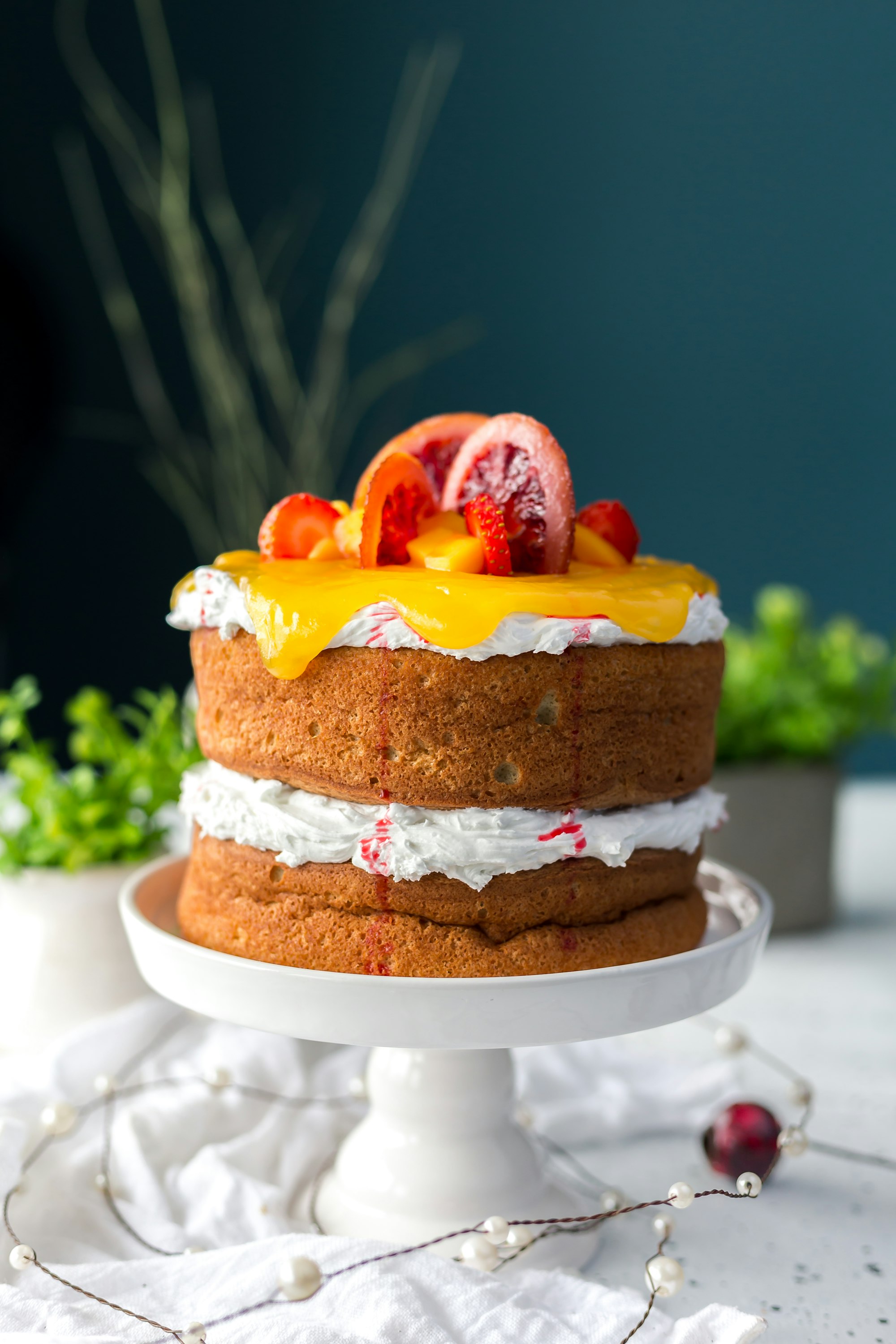 Two-layer cake topped with citrus and strawberries